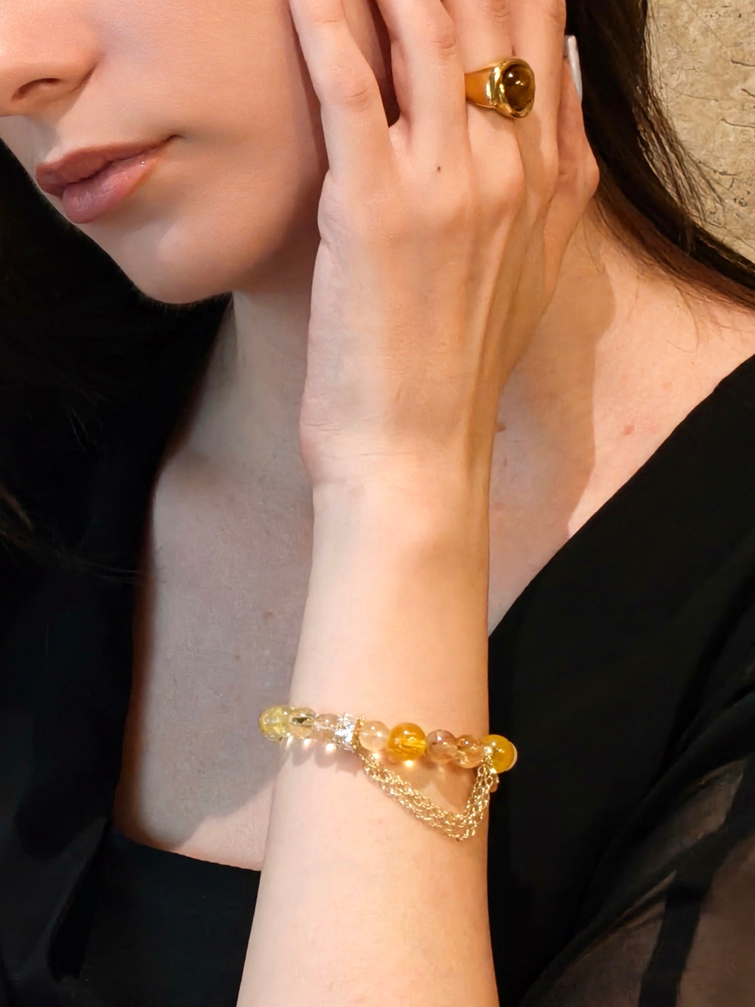Lifestyle shot of woman with citrine crystal bracelet and golden ring for success