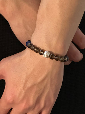 Last Quarter crystal bracelet worn on wrist, deep blue and smoky tones